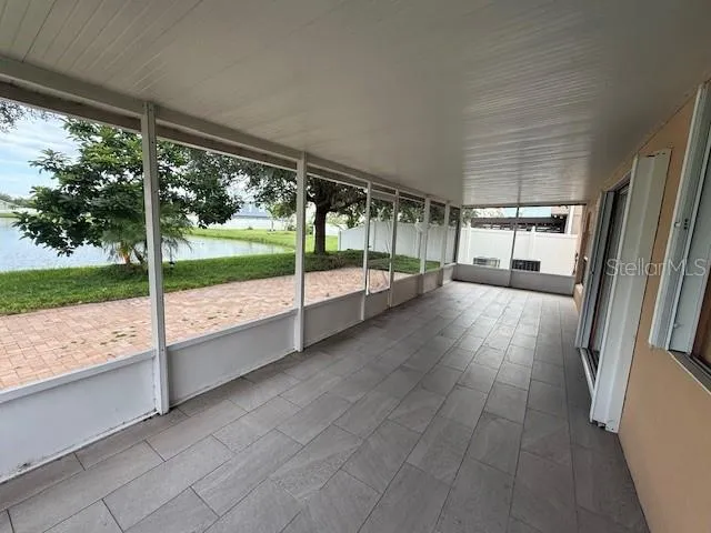 a view of an empty room with wooden floor and door