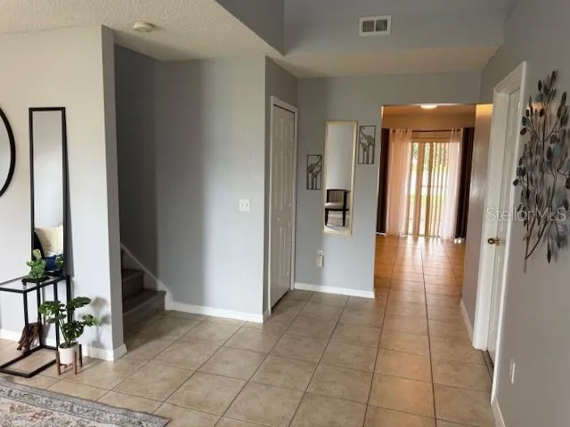 a view of a hallway with wooden floor and a living room