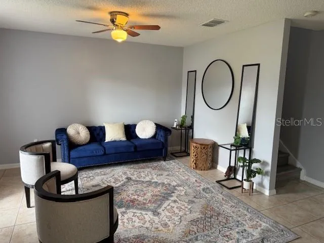 a living room with furniture a rug and white walls