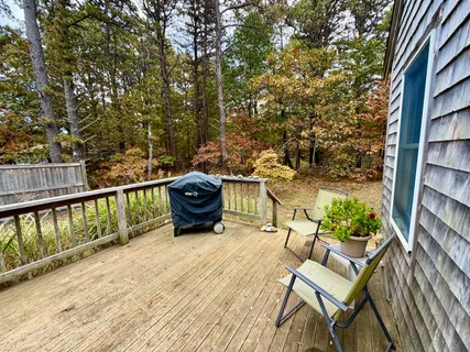 a roof deck with table and chairs and wooden floor