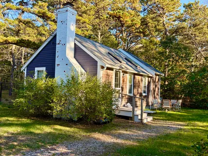 a view of a house with backyard and trees