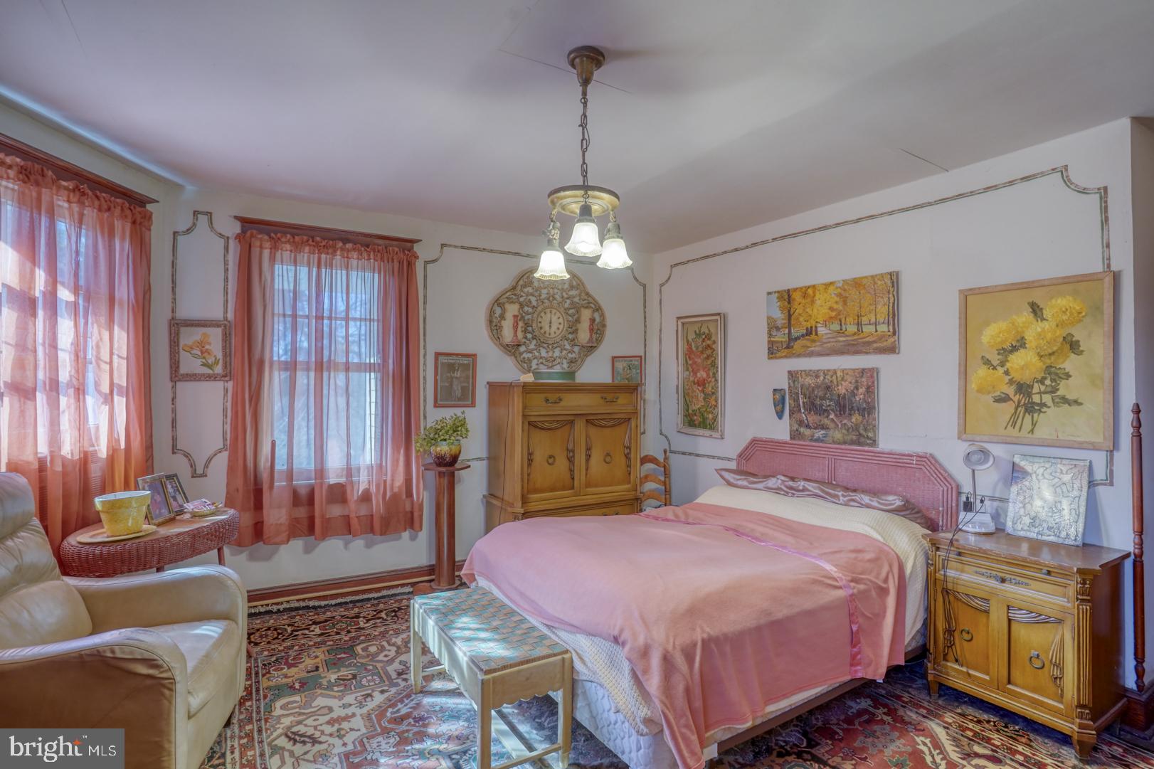 4096 Main Street Trappe, MD 21673 - Photo 48 of 70 a spacious bedroom with a bed a dresser and a chandelier