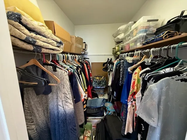 a view of walk in closet with clothes and shoes