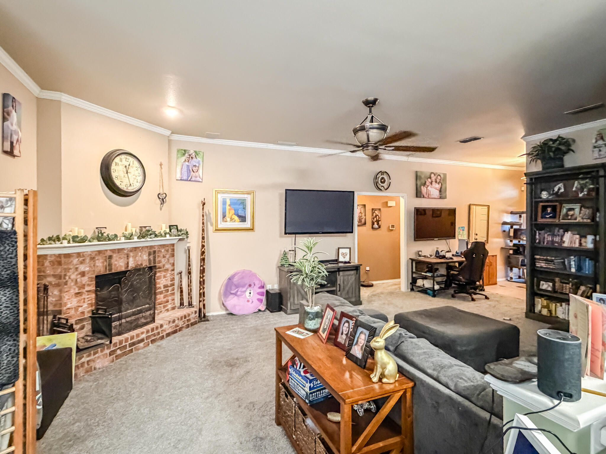 6715 91st Place Lubbock, TX 79424 - Photo 3 of 48 a living room with furniture a flat screen tv and a fireplace