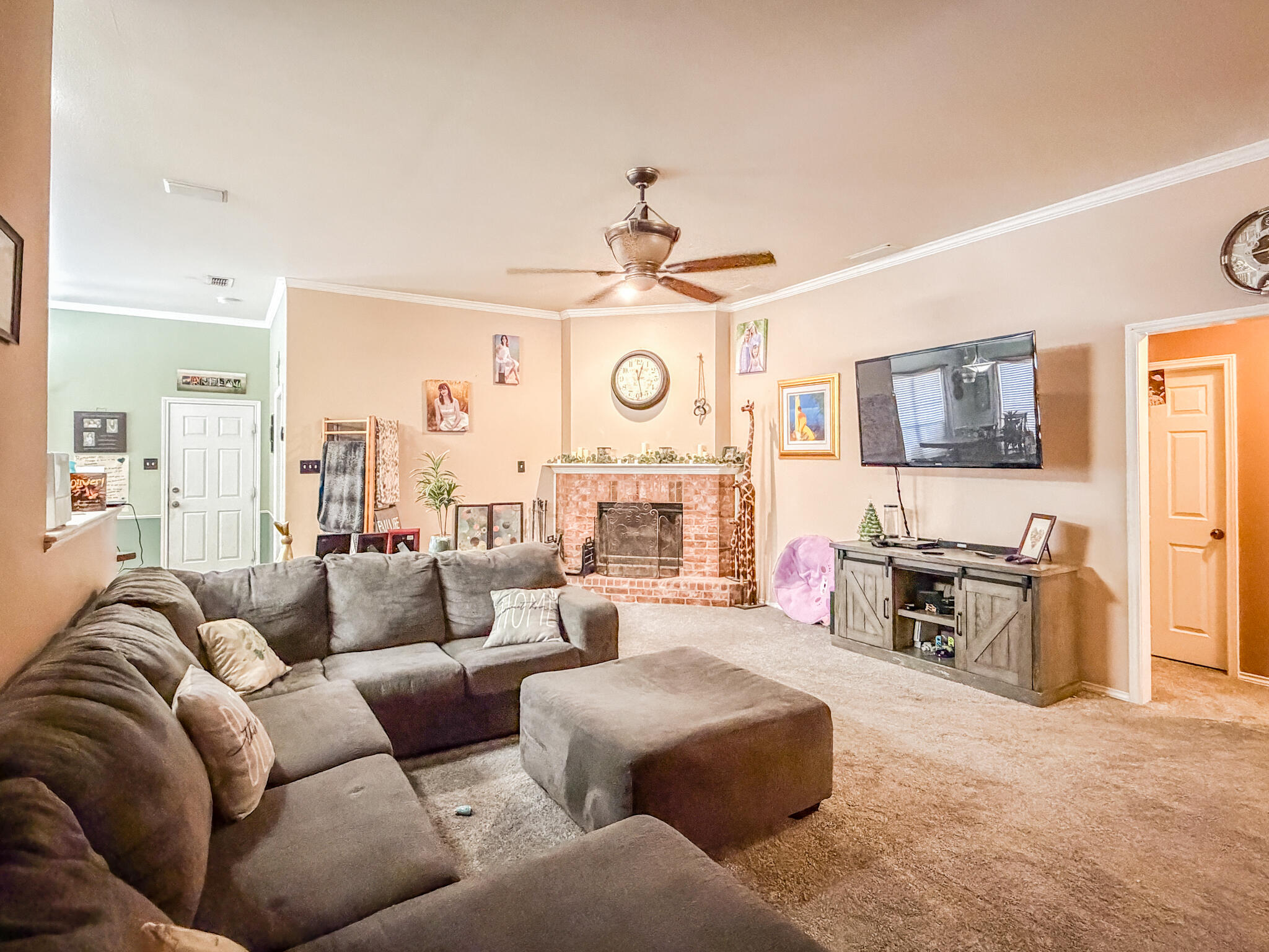 6715 91st Place Lubbock, TX 79424 - Photo 7 of 48 a living room with furniture a fireplace a clock and a large window