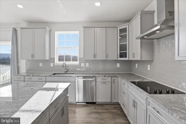 a kitchen with stainless steel appliances granite countertop a sink a stove and a refrigerator