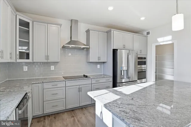 a kitchen with kitchen island granite countertop stainless steel appliances and a sink