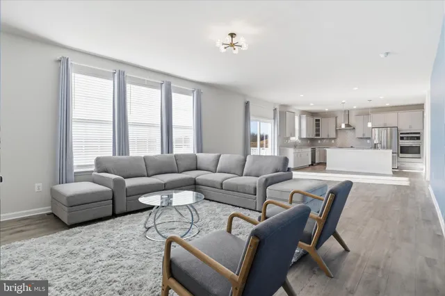 a living room with furniture a large window and a wooden floor