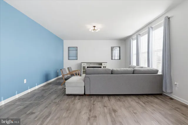 a living room with furniture and a view of kitchen