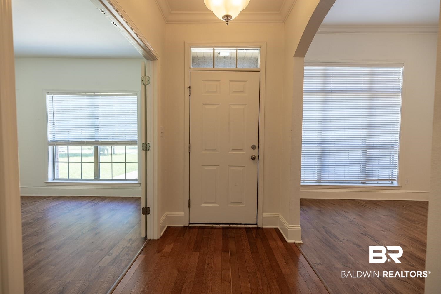 101 Normandy Street Fairhope, AL 36532 - Photo 3 of 18 Foyer entrance featuring arched walkways, dark wood-type flooring, and crown molding