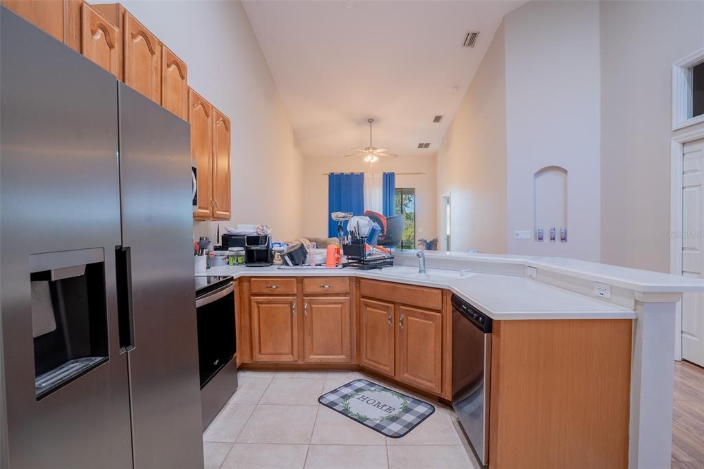 2739 Rutledge Court Winter Haven, FL 33884 - Photo 6 of 24 a kitchen with stainless steel appliances granite countertop a sink and a refrigerator
