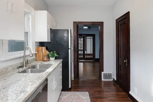 a kitchen with kitchen island granite countertop a sink and refrigerator