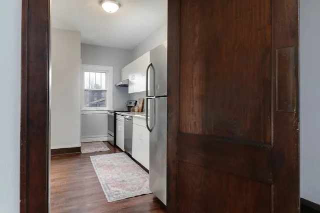 a kitchen with a refrigerator and white cabinets