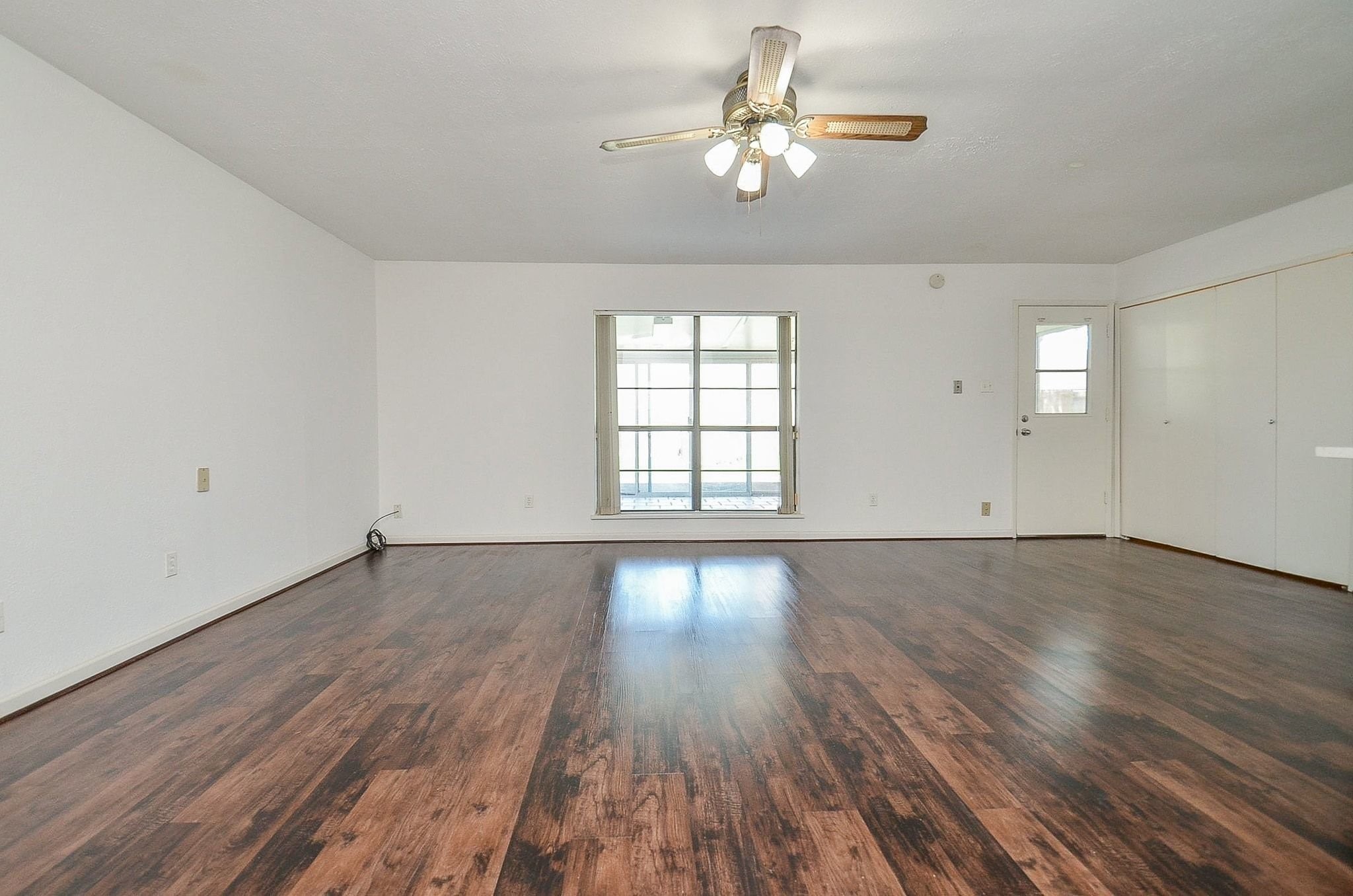 17518 Autumn Trails Lane Houston, TX 77084 - Photo 18 of 30 an empty room with wooden floor chandelier fan and windows