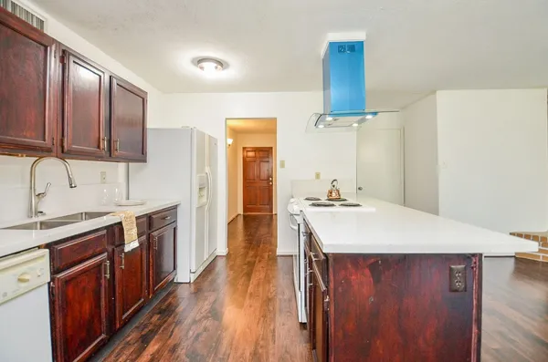 a kitchen with a sink cabinets and wooden floor