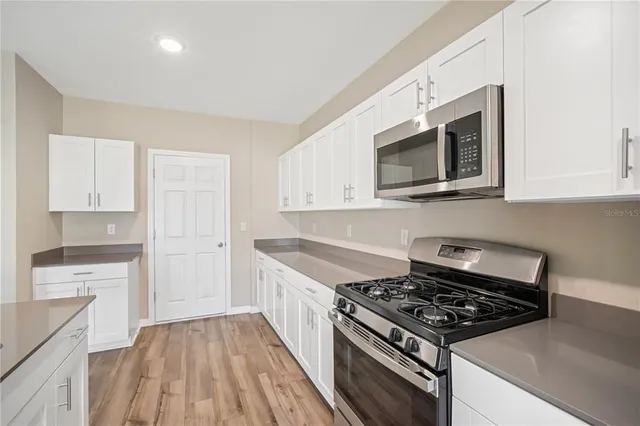 a kitchen with stainless steel appliances a stove a microwave and cabinets