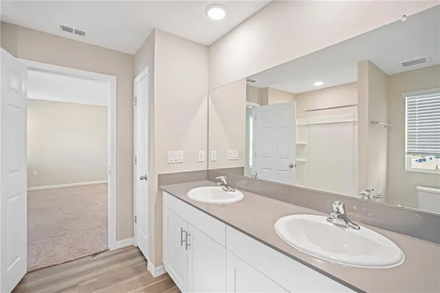 a bathroom with double vanity sinks and a mirror