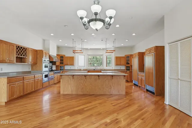a large kitchen with kitchen island a large counter top space appliances and cabinets