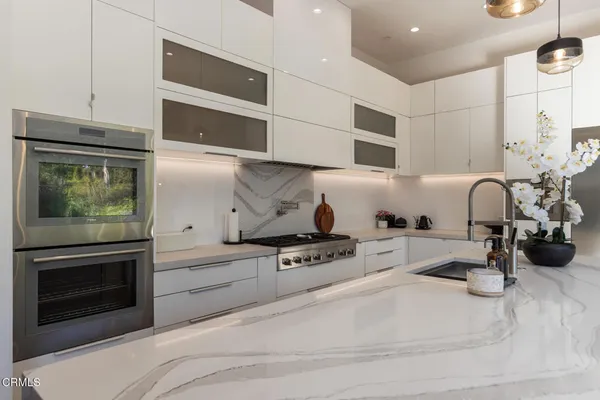 a kitchen with sink stove and cabinets