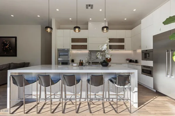 a kitchen with stainless steel appliances granite countertop a sink a stove and a wooden floors