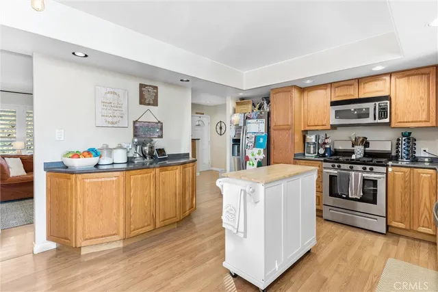a kitchen with stainless steel appliances a stove a sink dishwasher and a refrigerator