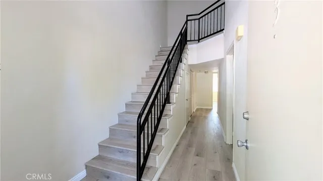 a view of staircase with wooden floor and white walls