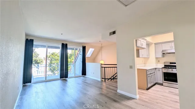 a view of a kitchen with wooden floor and a window