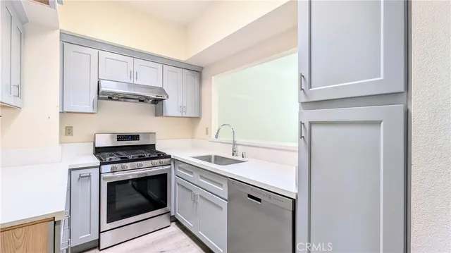 a kitchen with stainless steel appliances granite countertop a sink and a stove