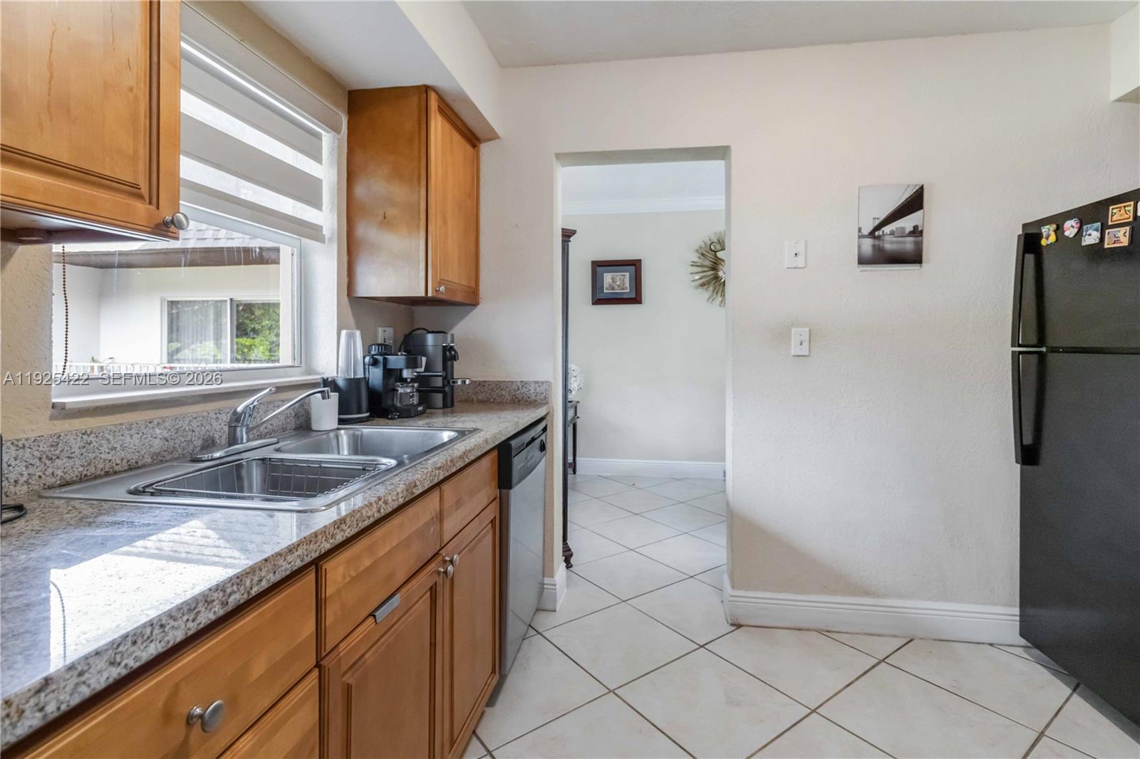 8475 Southwest 94th Street, Unit 217E Miami, FL 33156 - Photo 13 of 21 a kitchen with a sink and a refrigerator