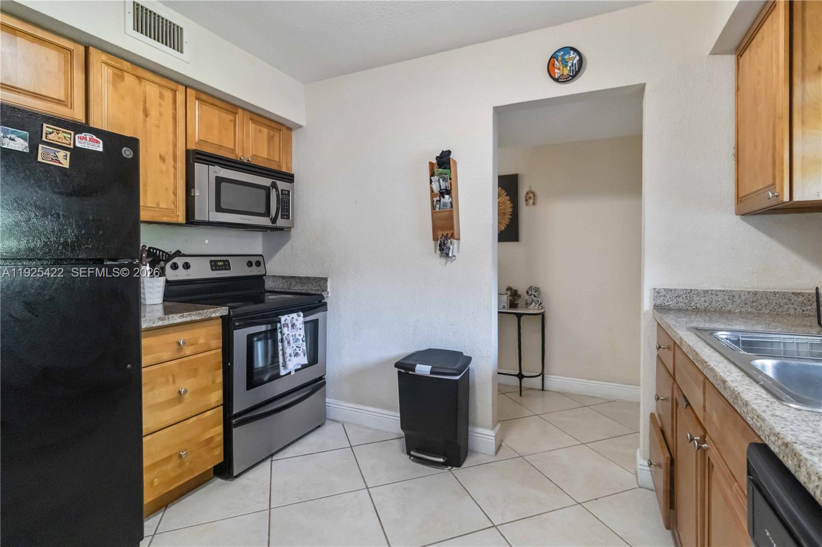 8475 Southwest 94th Street, Unit 217E Miami, FL 33156 - Photo 14 of 21 a kitchen with stainless steel appliances granite countertop a stove a sink and a refrigerator
