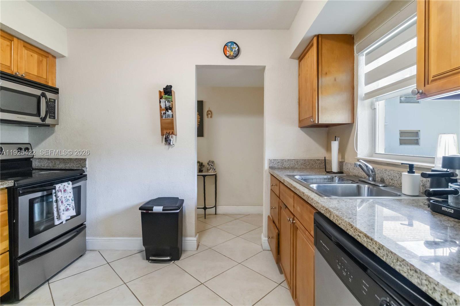 8475 Southwest 94th Street, Unit 217E Miami, FL 33156 - Photo 4 of 21 a kitchen with a sink stove top oven and microwave