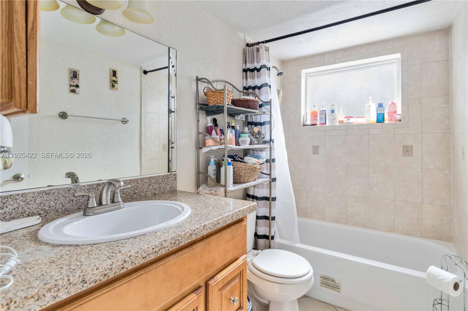 8475 Southwest 94th Street, Unit 217E Miami, FL 33156 - Photo 8 of 21 a bathroom with a granite countertop sink toilet and shower