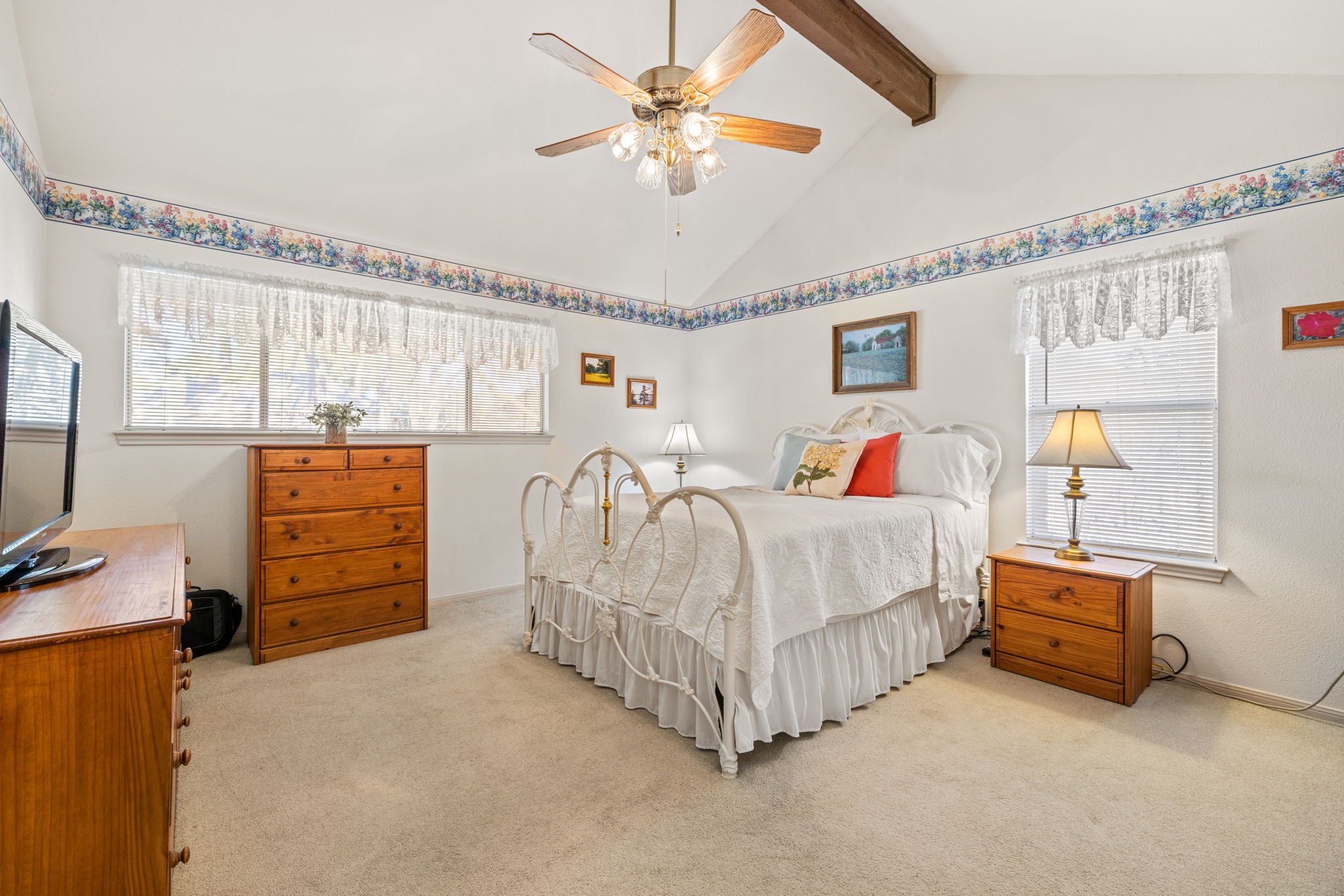 9102 Woodhouse Drive Spring, TX 77379 - Photo 15 of 32 PRIMARY BEDROOM - This room has a vaulted ceiling with wood beam. It has a nice open feel, especially with the 2 windows providing lots of natural light.