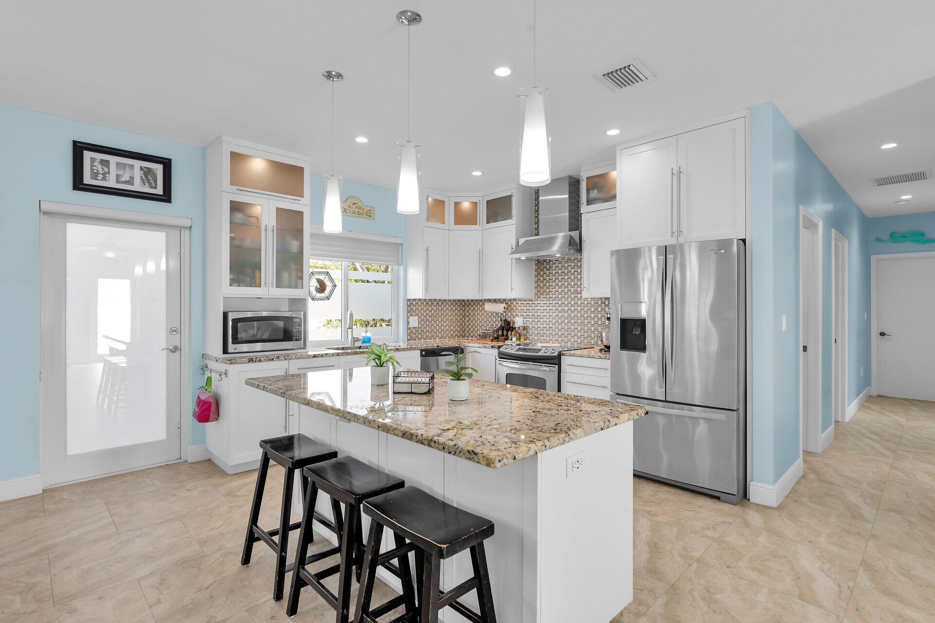 a kitchen with stainless steel appliances granite countertop a refrigerator and a stove top oven