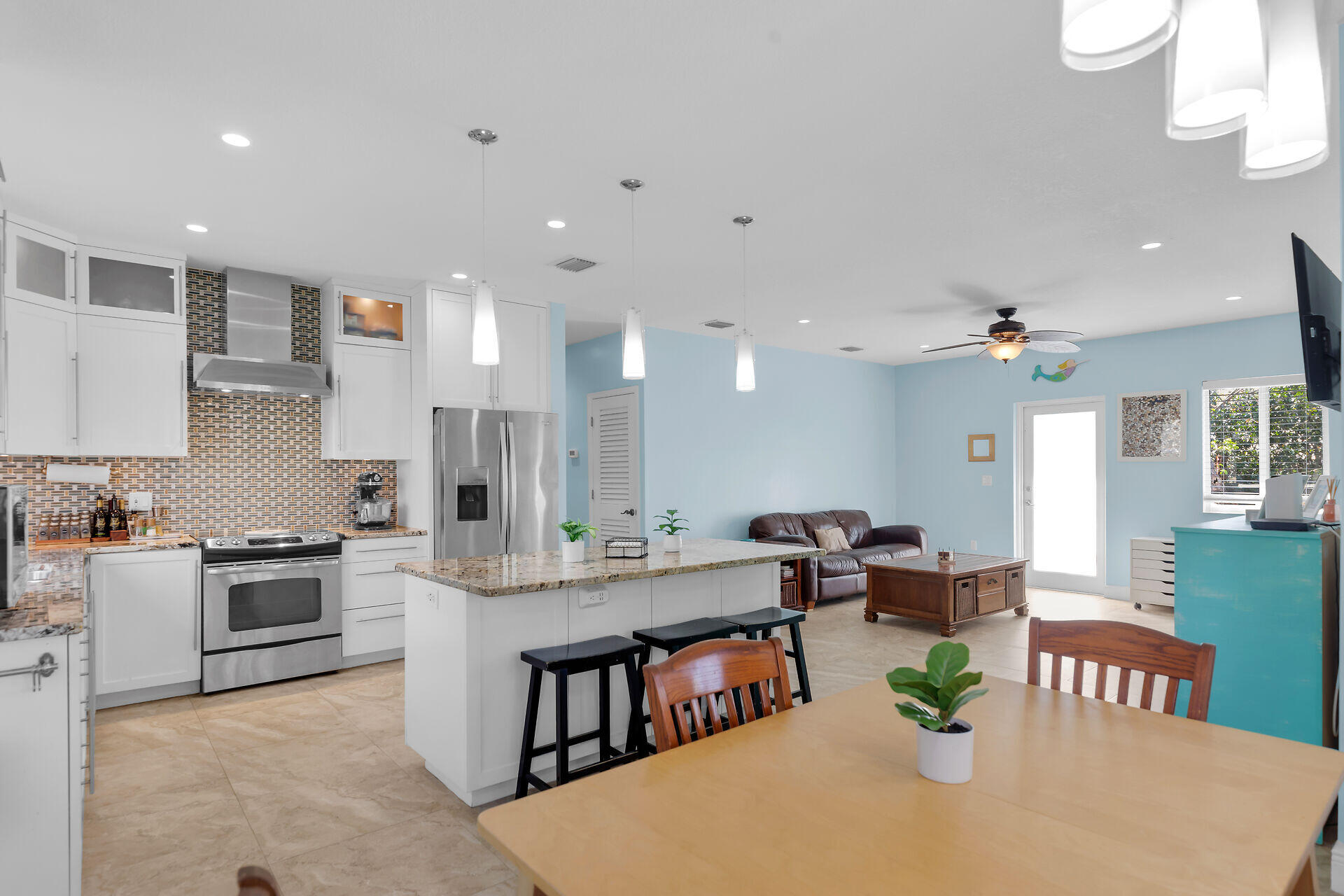 1019 Snapper Lane Key Largo, FL 33037 - Photo 12 of 49 a large kitchen with kitchen island a stove a sink a dining table and chairs