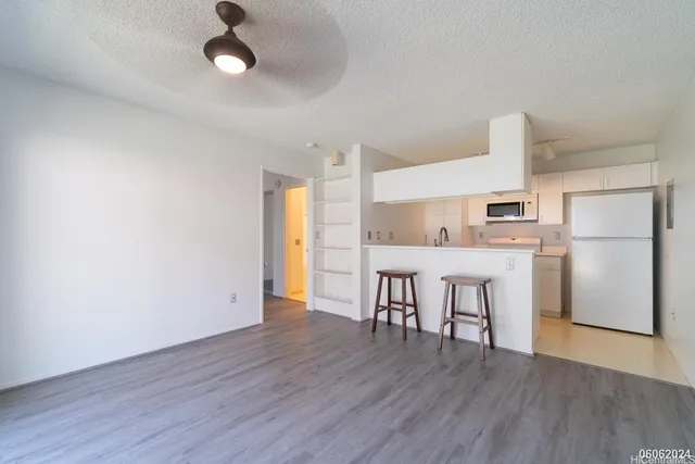 a view of kitchen with refrigerator microwave and wooden floor