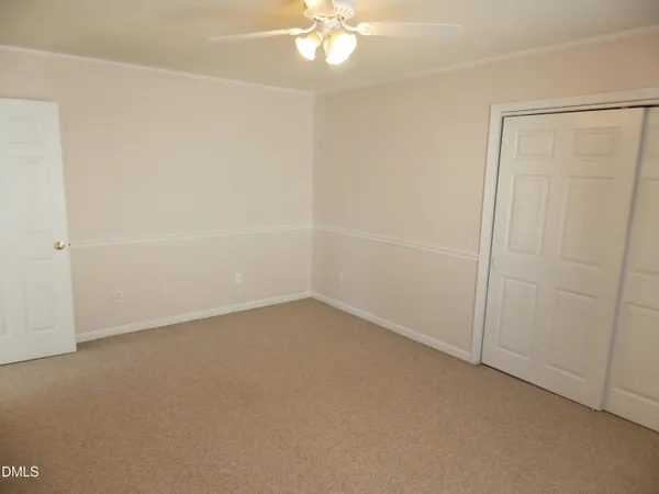 an empty room with a fan and a window