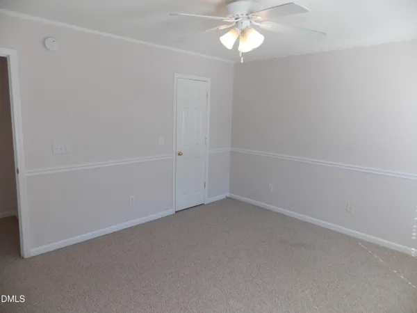 an empty room with a chandelier fan