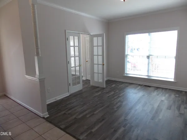 an empty room with wooden floor and windows