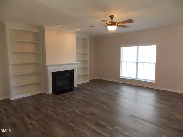 an empty room with windows and a fireplace