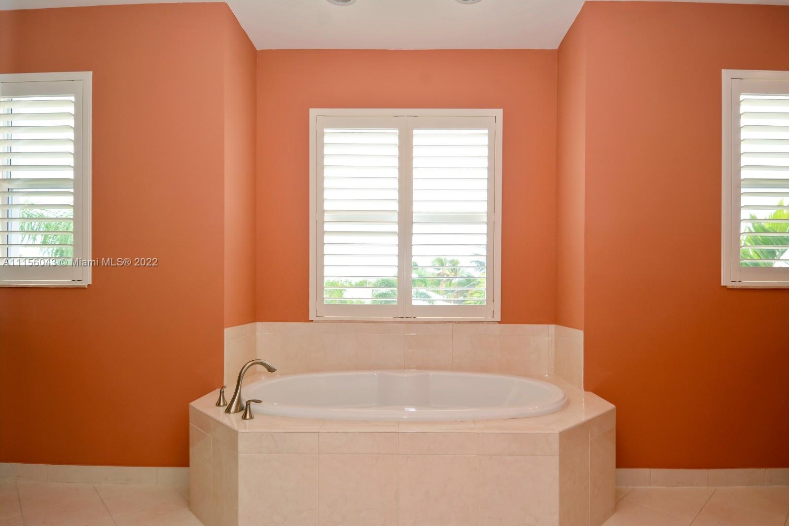 1960 Northeast 33rd Street Lighthouse Point, FL 33064 - Photo 14 of 24 a white bath tub sitting in a bathroom next to a window