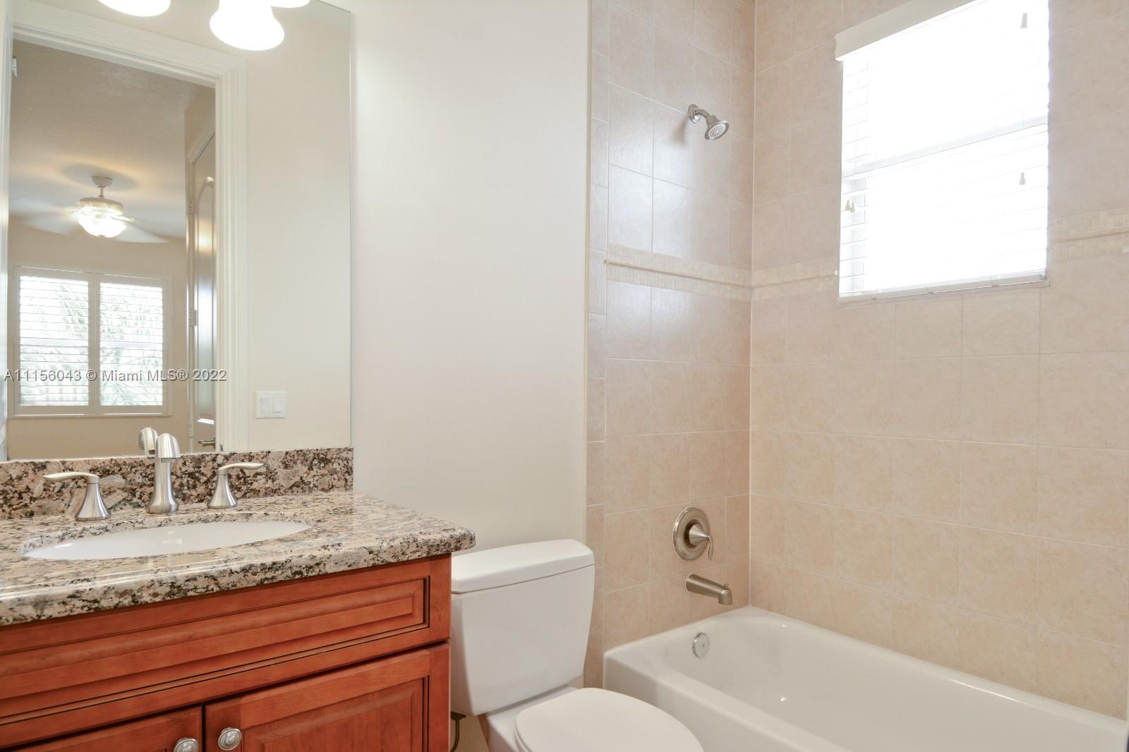 1960 Northeast 33rd Street Lighthouse Point, FL 33064 - Photo 19 of 24 a bathroom with a granite countertop sink a toilet and shower