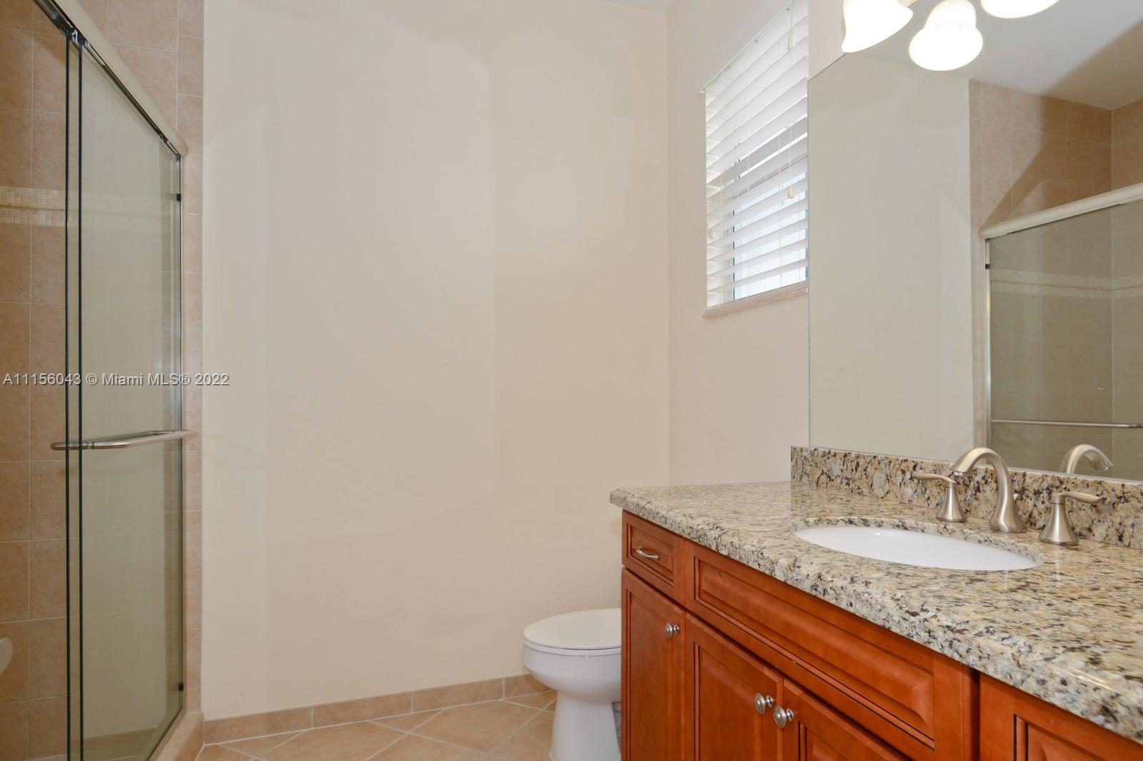 1960 Northeast 33rd Street Lighthouse Point, FL 33064 - Photo 20 of 24 a bathroom with a granite countertop sink a toilet and a mirror