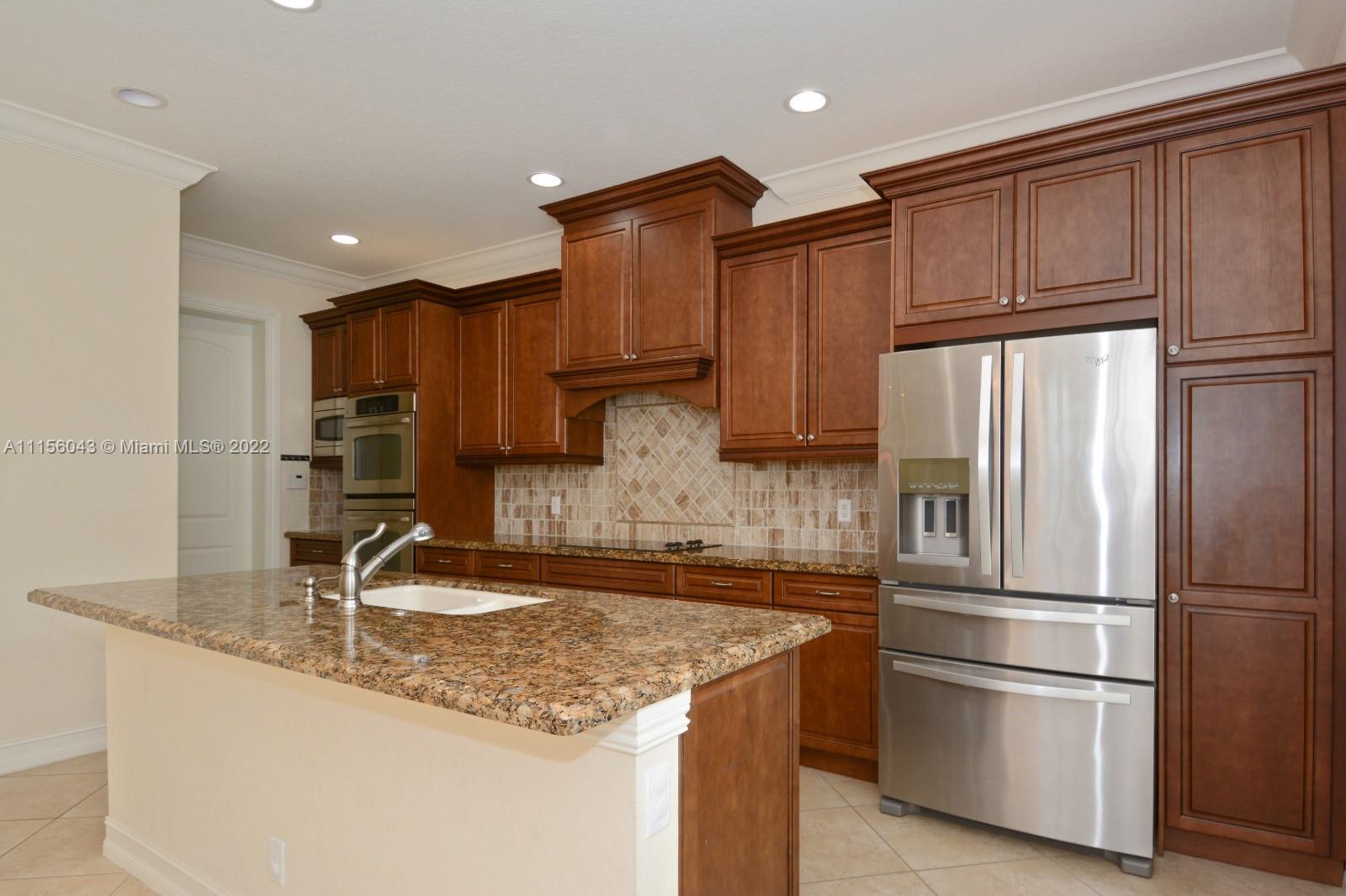 1960 Northeast 33rd Street Lighthouse Point, FL 33064 - Photo 3 of 24 a kitchen with stainless steel appliances granite countertop a refrigerator and a sink