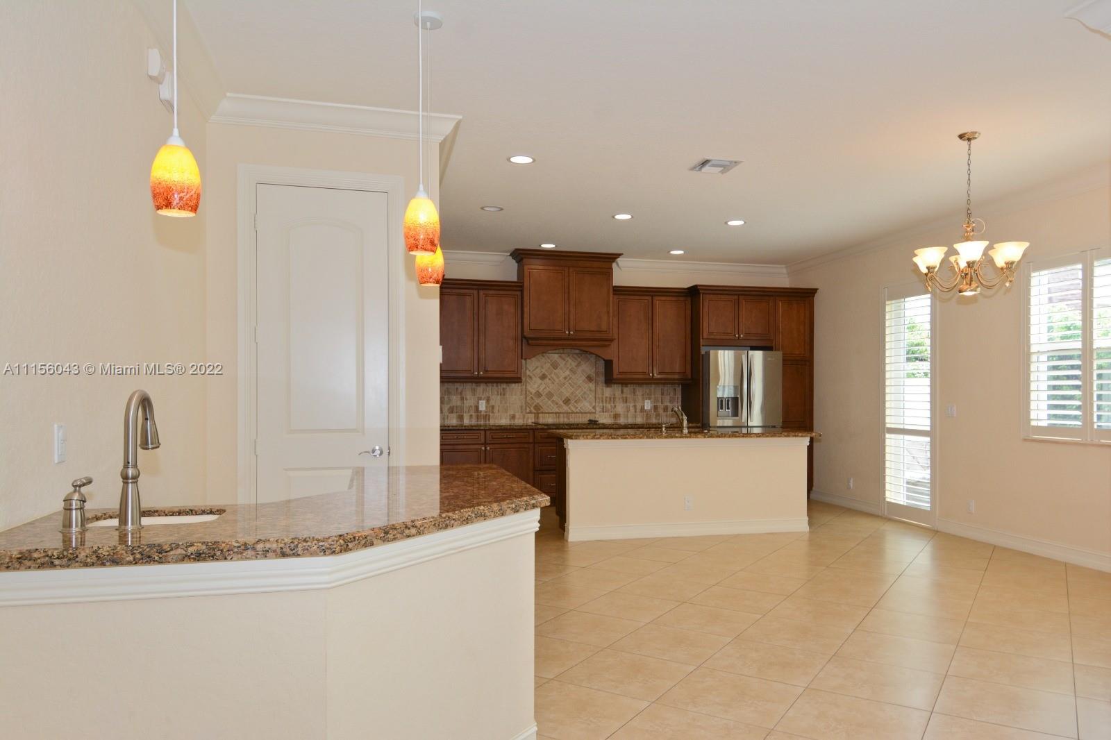 1960 Northeast 33rd Street Lighthouse Point, FL 33064 - Photo 9 of 24 a kitchen with kitchen island a sink stainless steel appliances and cabinets