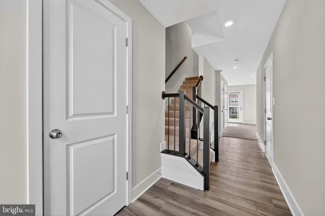 a view of a hallway with wooden floor and staircase