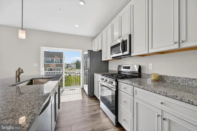 a kitchen with stainless steel appliances granite countertop a sink stove and cabinets
