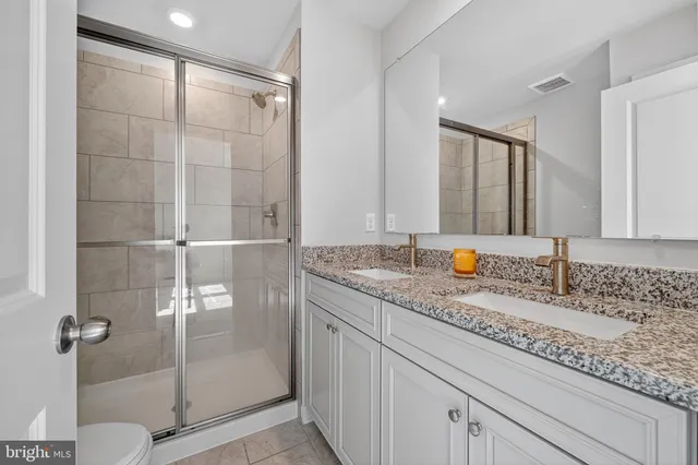 a bathroom with double sink and a mirror