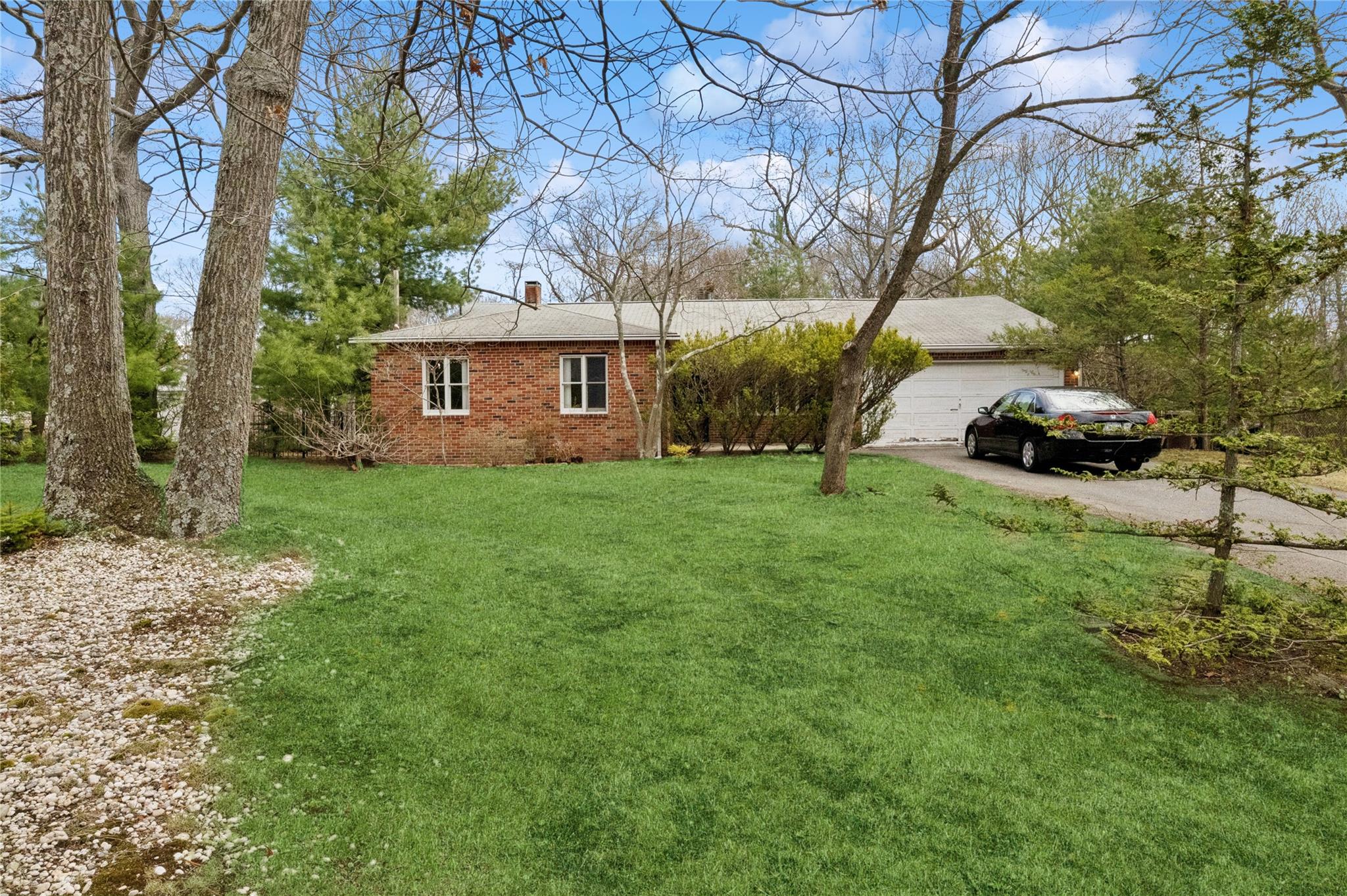 a view of a house with a yard and large trees