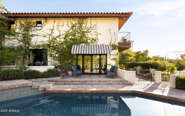 a view of a house with backyard and sitting area
